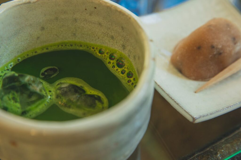 Close-up of a cup of matcha tea accompanied by a traditional Japanese sweet wagashi.